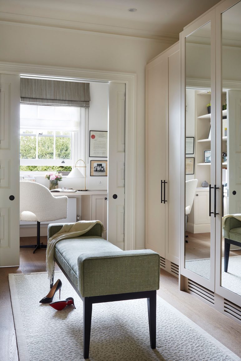 a neutral dressing room with central bench and a private office in the background