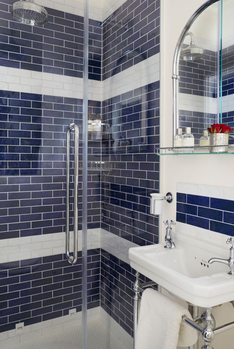 A luxury bathroom with navy blue subway tiles
