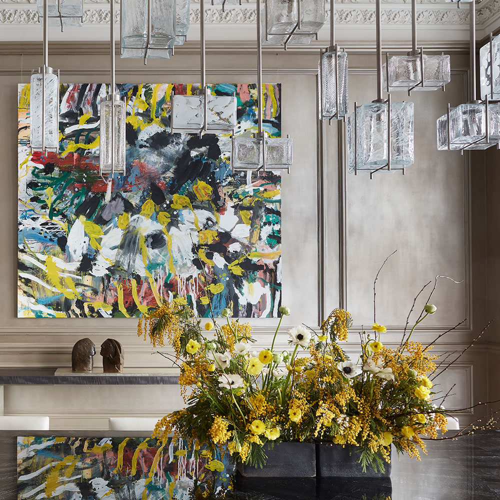 A Studio Indigo project of a grey dining room, with colourful art, flowers and glass pendants